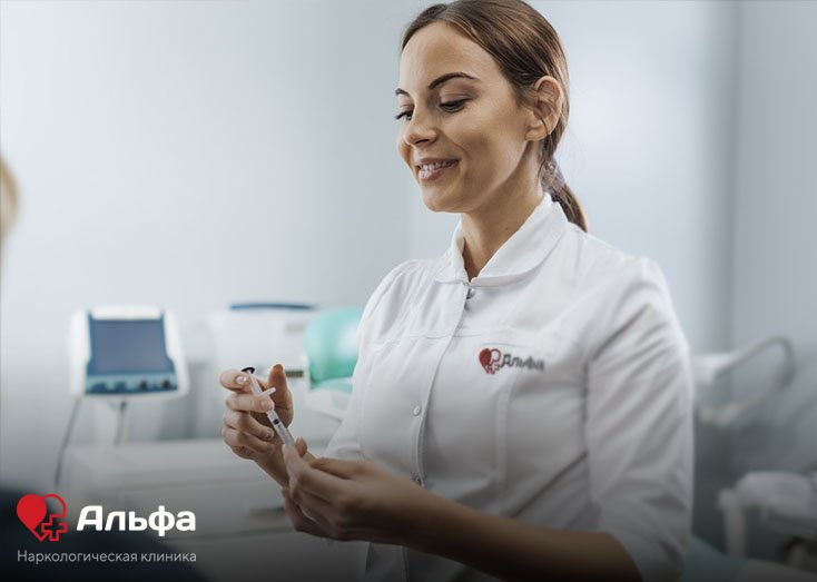 Женщина врач со шприцом в руке